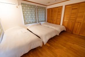 two beds in a room with wooden floors and wooden cabinets at Lilla nasu in Nasu