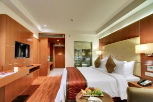 a hotel room with a large bed and a table at Lavender Premier in Bangalore +42 photos