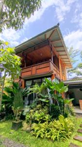 a house with a balcony and some plants at Ratu Roso Resort in Malang