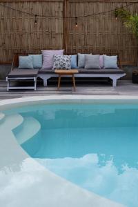 a couch sitting next to a swimming pool at Karma Kayak in Gili Trawangan