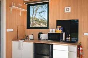 a kitchen with a counter with a microwave and a sink at Little Haven Cottage X by Tiny Away in Balliang