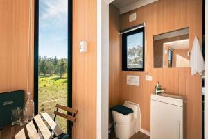 a bathroom with a toilet and a window at Little Haven Cottage X by Tiny Away in Balliang +8 photos