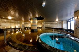 a large swimming pool in a large building at Kanazawa Hakuchoro Hotel Sanraku -Natural Hot Spring- in Kanazawa