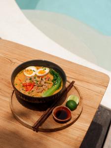 a bowl of food with eggs and vegetables on a table at Karma Kayak in Gili Trawangan +48 photos