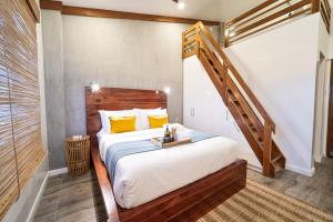 a bedroom with a large bed and a wooden staircase at The Wander Nest Villas in Panglao Island +39 photos