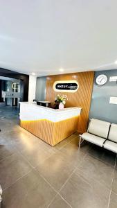 a lobby with a waiting area with a bench and a clock at Innzoy Comforts - Hitech City Hyderabad in Hyderabad