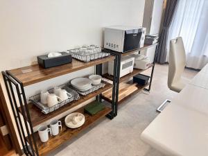 a room with a microwave and some dishes on shelves at Fierement inn in Sapporo