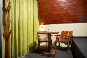 a room with a table and a green curtain at Nagalakanda Eco Lodge in Millewa