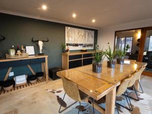 a dining room with a table and some plants at Ntoma House in Hoedspruit