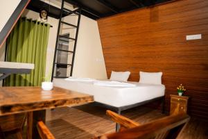 a room with a bed and a table and chairs at Nagalakanda Eco Lodge in Millewa