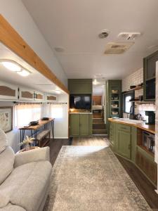 a living room with a couch and a kitchen at The Pendle-Tin in Pendleton