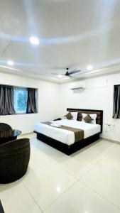 a bedroom with a king sized bed and a couch at Innzoy Comforts - Hitech City Hyderabad in Hyderabad +60 photos