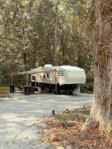 a white trailer parked in a parking lot next to a tree at The Pendle-Tin in Pendleton