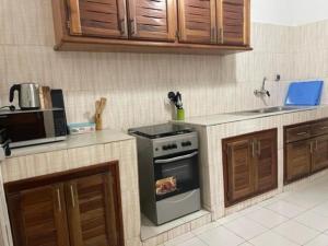 a kitchen with a stove and a microwave at MySuiteStays Keyless 3Bed Apt in Sacre Coeur in Dakar