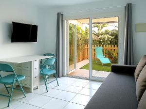 a living room with a couch and a desk and chairs at Maspalomas Green Oasis 1404 in Maspalomas