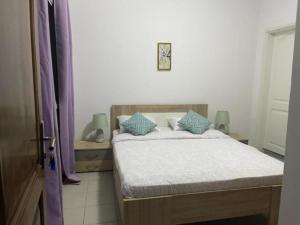 a bedroom with a bed with blue pillows on it at MySuiteStays Keyless 3Bed Apt in Sacre Coeur in Dakar