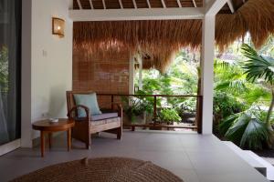 a living room with a chair and a table at Karma Kayak in Gili Trawangan