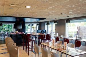 a restaurant with tables and chairs and a bar at Campanile Evry Ouest - Corbeil Essonnes in Corbeil-Essonnes