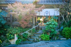 a building with a garden with stairs in front of it at Ryokan Kiraku in Beppu