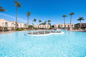 a large swimming pool in a resort with palm trees at Maspalomas Green Oasis 1404 in Maspalomas