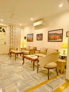 a living room with couches and chairs and a table at Ramat Niwas By Kutani Stays in Jaipur
