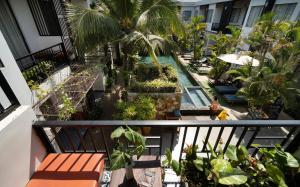 an apartment balcony with a swimming pool and palm trees at Central Corner Suite in Siem Reap