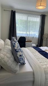 a bedroom with a large bed with a window at Sochi A double bed Room in a nice home in Upper Hutt
