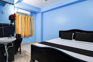 a bedroom with a bed and a sink and blue walls at HOTEL O RAHAN APPARTMENT in New Town