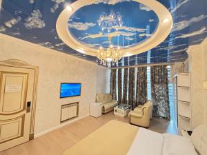 a bedroom with a bed and a ceiling with a chandelier at Agava Tbilisi in Tbilisi City