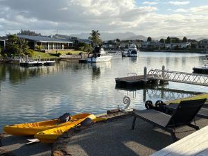 a yellow kayak and a chair next to the water at Mermaid Waterways in Whitianga