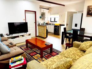 a living room with a couch and a table at Sable Suites B1, 1 Bed Apartments in Kabulonga in Lusaka