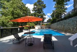 a table and chairs with an umbrella next to a pool at Comfort & Convenience in Stone Mountain in Stone Mountain