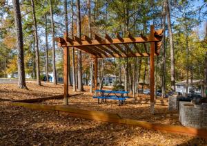 a blue bench in a park with a wooden canopy at Comfort & Convenience in Stone Mountain in Stone Mountain