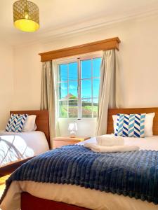a bedroom with two beds and a window at "Fifi House" in Estreito da Calheta