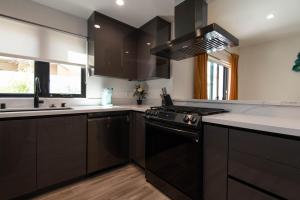 a kitchen with black cabinets and a stove top oven at Regency Modern Apartments in Glendale +39 photos