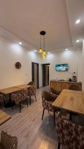 a dining room with tables and chairs and a tv at Al Fayz Boutique in Bukhara +20 photos