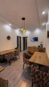 a room with tables and chairs and a tv at Al Fayz Boutique in Bukhara