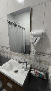 a bathroom with a sink and a blow dryer at Al Fayz Boutique in Bukhara