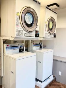 a laundry room with two washers and a dryer at HOTEL LiVEMAX BUDGET Chofu-Ekimae in Chofu