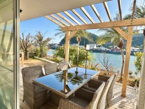 a patio with a table and chairs and a view of the water at Waterfront Hideaway in Miyazaki
