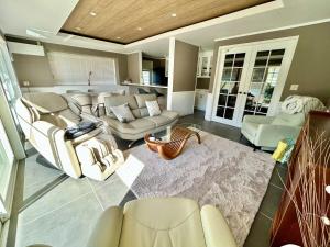 a large living room with couches and chairs at Waterfront Hideaway in Miyazaki