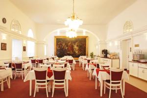 a large dining room with white tables and chairs at Lázeňský Hotel Sadový Pramen in Karlovy Vary