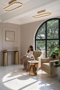 a woman sitting on a couch in a living room at Grandala Suites - A Boutique Hotel in Cochin