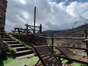 two wooden chairs sitting next to a set of stairs at CASA RURAL CORTIJO MOLINO ALTERO in Trevélez