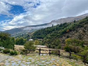 a wooden bench sitting on top of a mountain at CASA RURAL CORTIJO MOLINO ALTERO in Trevélez +28 photos