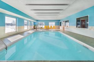 a large swimming pool with blue walls at Super 8 by Wyndham Kokomo in Kokomo
