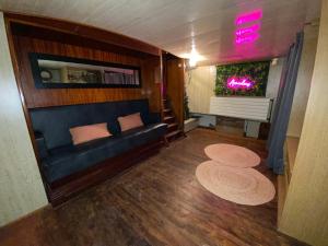 a living room with a blue couch and a window at Péniche Amadeus conviviale et cosy , proche de Disney et de Paris in Torcy