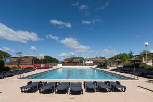 a large swimming pool with lounge chairs at Chez gaby in Lagorce