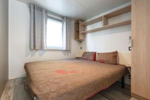 a small bedroom with a bed with a window at Chez gaby in Lagorce