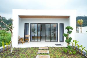 a white house with glass doors and a patio at Villa Jepun Segara Giri in Kubupenlokan